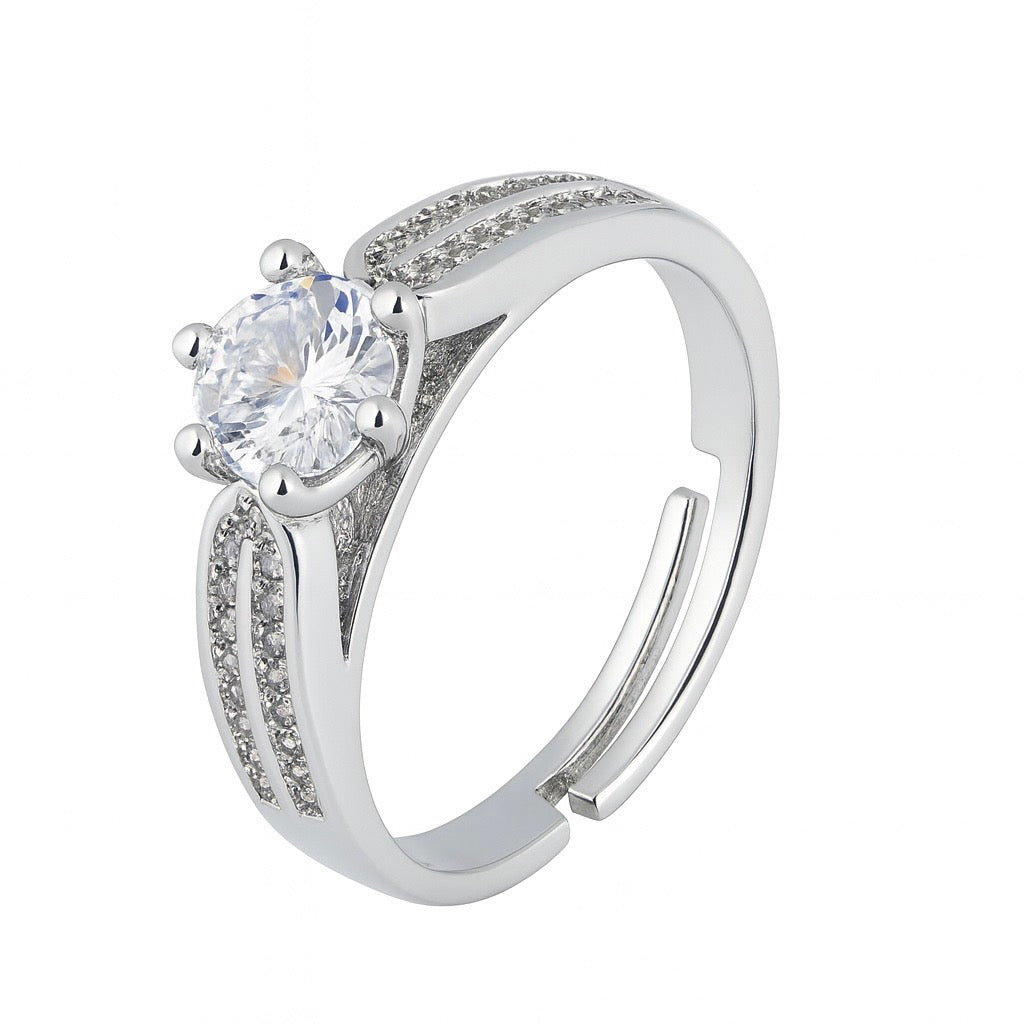 Inel din argint cu o piatră centrală transparentă, strălucitoare, montată într-un design clasic, cu detalii fine pe bandă.