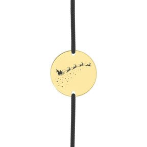 Brățară cu șnur negru și disc din argint placat cu aur 18K, gravat pe față cu Moș Crăciun în sanie și renii, iar pe verso cu un mesaj personalizat cu numele copilului.