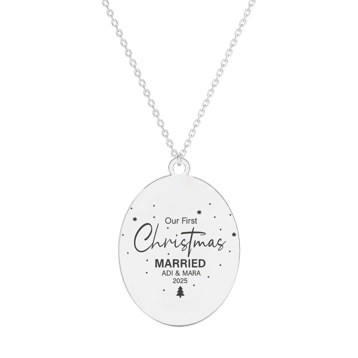 Colier din argint 925 cu lanț fin de 40 cm și prelungitor de 5 cm, având un pandantiv oval gravat cu textul “Our First Christmas Married”, nume personalizabile și mici simboluri de Crăciun.