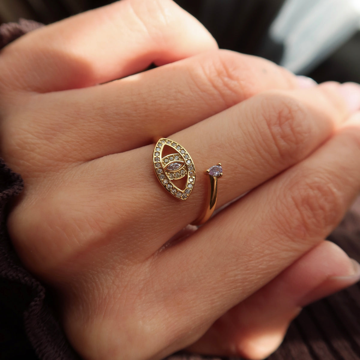 Inel reglabil din argint placat cu aur 18K, cu design în formă de ochi protector, decorat cu zirconii mici și o piatră roz marquise în centru, plus o piatră rotundă în partea superioară a inelului.