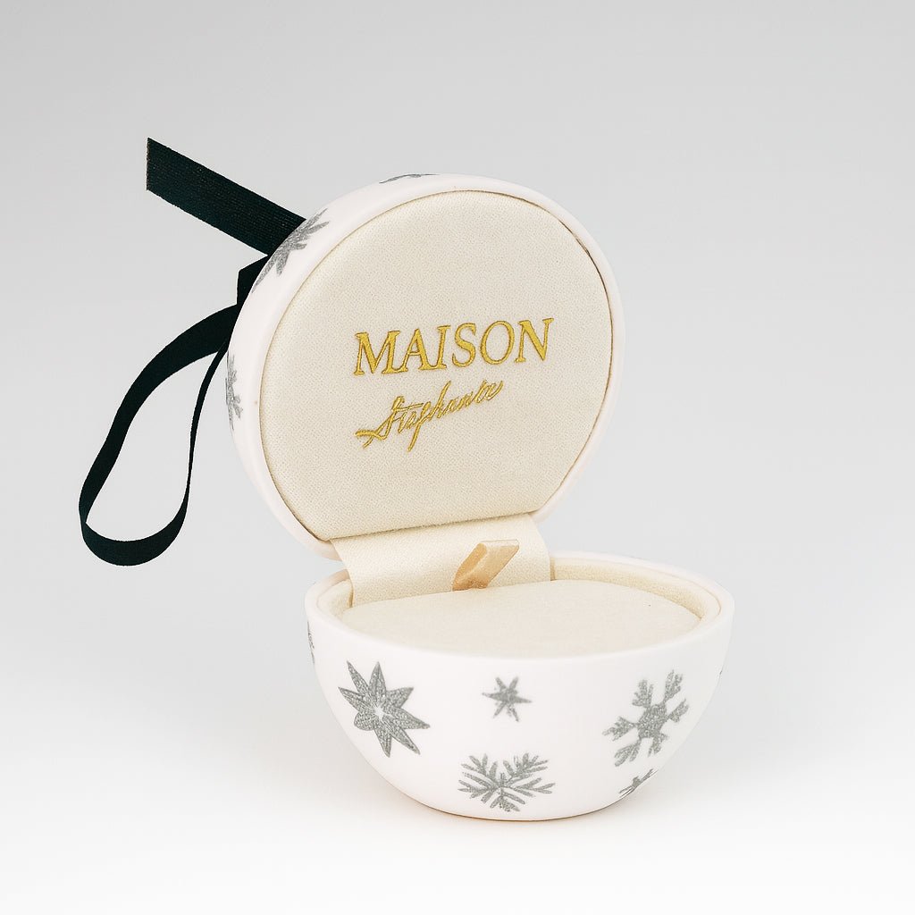 Glob decorativ alb cu fulgi argintii și panglică neagră, care se deschide ca o cutie de bijuterii cu interior crem catifelat și broderie aurie Maison La Stéphanie.
