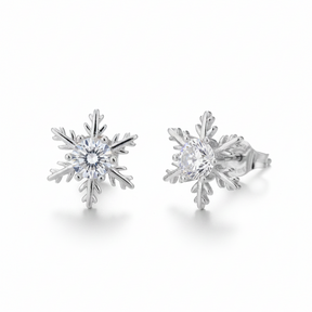O pereche de cercei mici tip stud, în formă de fulg de nea, realizați din argint cu finisaj lucios. În centru se află o piatră strălucitoare transparentă, cu un design simetric și delicat.