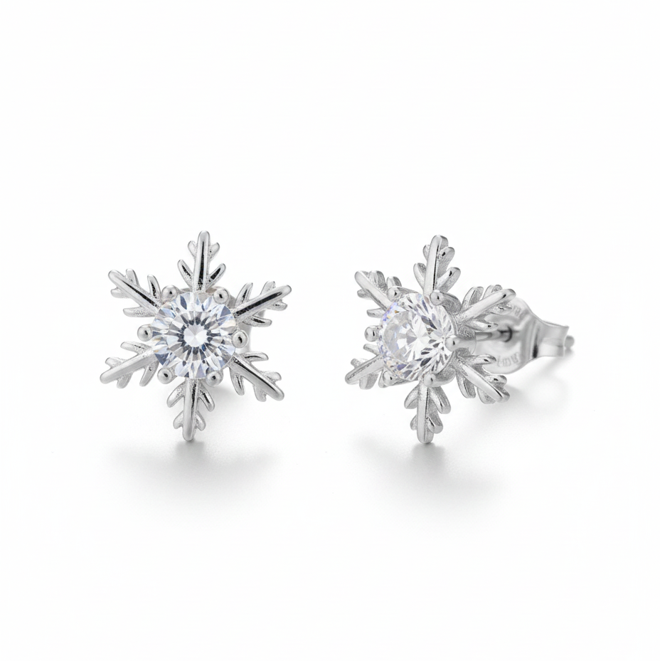 O pereche de cercei mici tip stud, în formă de fulg de nea, realizați din argint cu finisaj lucios. În centru se află o piatră strălucitoare transparentă, cu un design simetric și delicat.