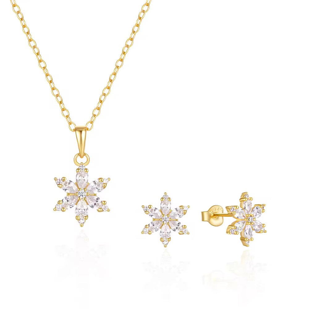 Set de bijuterii din argint placat cu aur 18K, cu pandantiv fulg de nea pe lanț subțire și cercei stud asortați, ambele piese decorate cu zirconii tăietură marquise și rotundă.